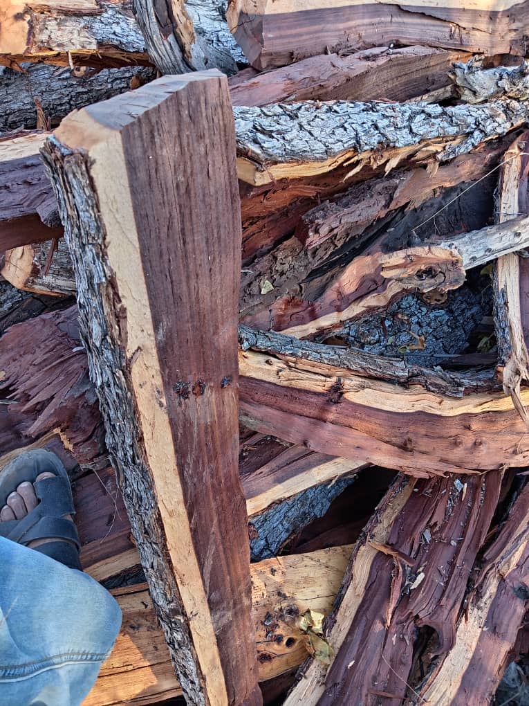 Stack of varied reddish-brown split wood, some with bark, perfect for home use, ready as premium Namibian Firewood Cape Town.